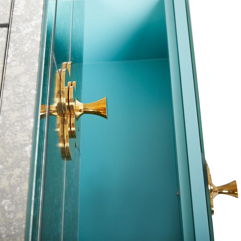 A luxurious six-drawer brass and antiqued mirror glass chest