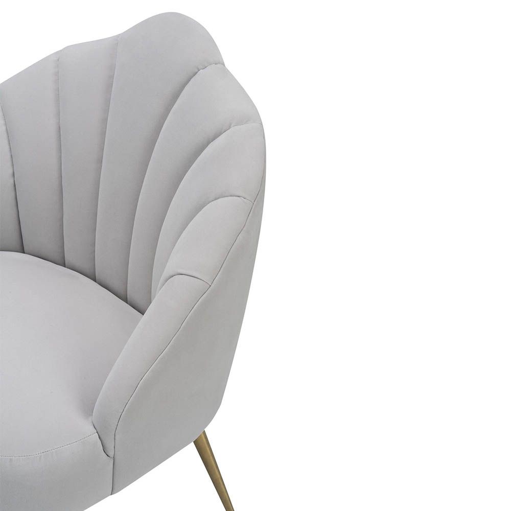 Light grey velvet chair with statement leaf backrest and tapered brass legs