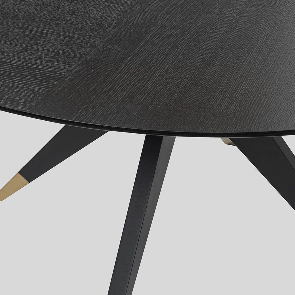Dining table with statement base of slender spokes and brass caps