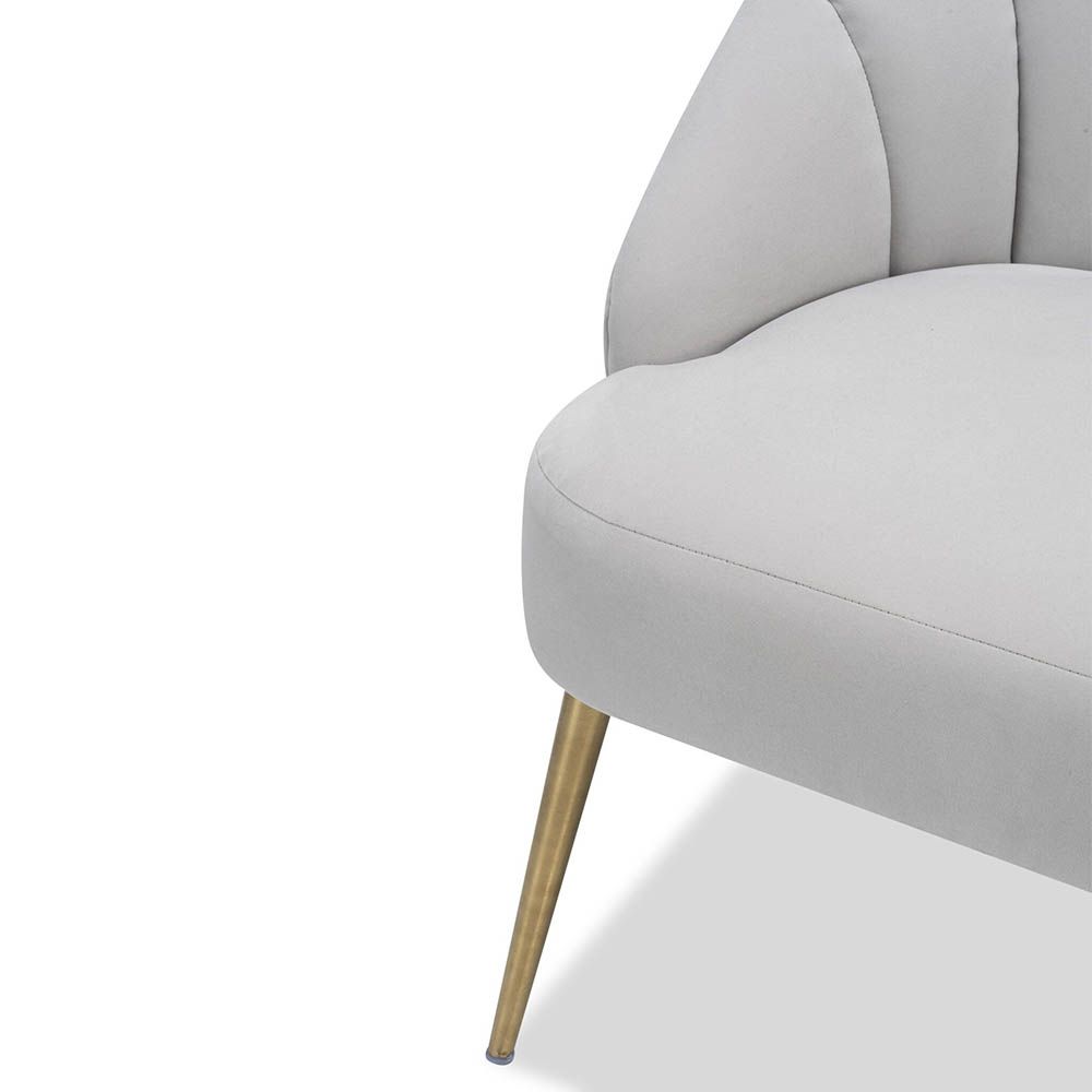 Light grey velvet chair with statement leaf backrest and tapered brass legs