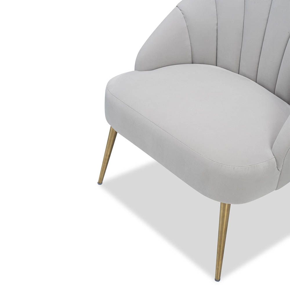 Light grey velvet chair with statement leaf backrest and tapered brass legs