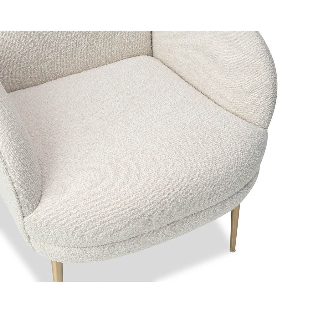 Artisan curved armchair finished in boucle sand with brass legs