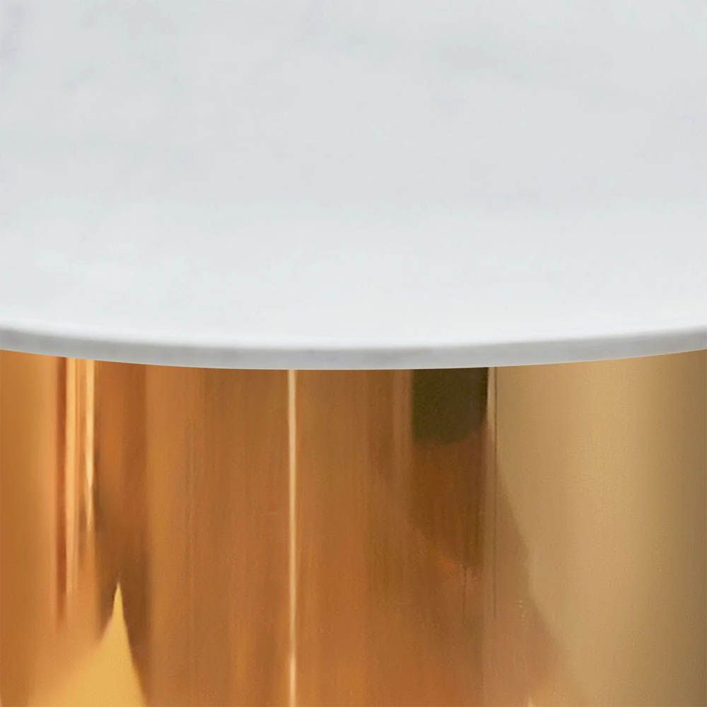 A glamorous dining table by Jonathan Adler with a brass base and marble top