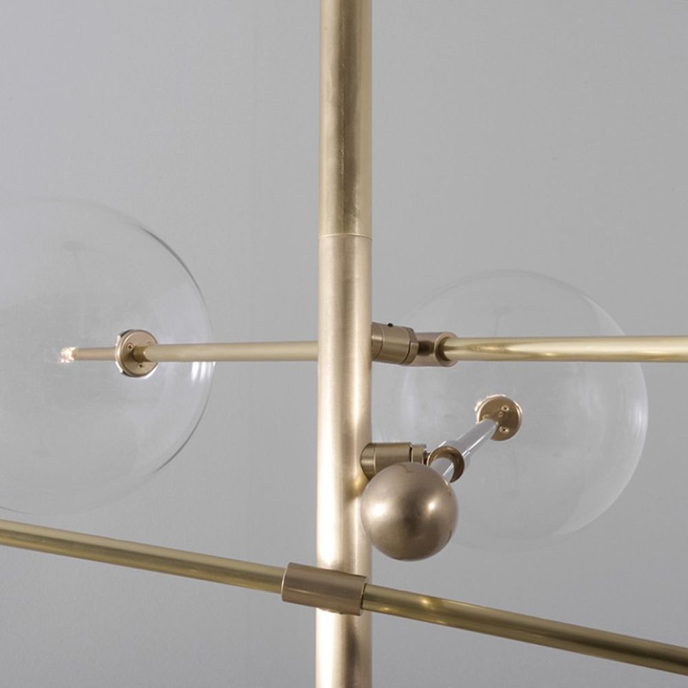 Industrial style 6 arm chandelier in a natural brass finish with 6 clear glass globe bulbs