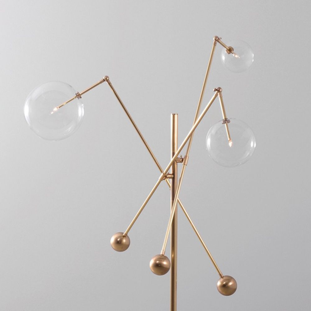 Natural brass industrial style floor lamp with 3 angular arm design with clear glass globe lampshades