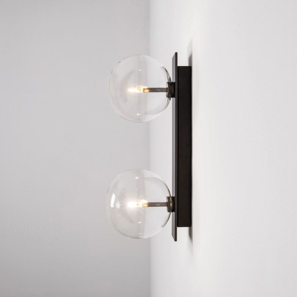 A chic, double light wall lamp with glass lampshades and a black gunmetal finish