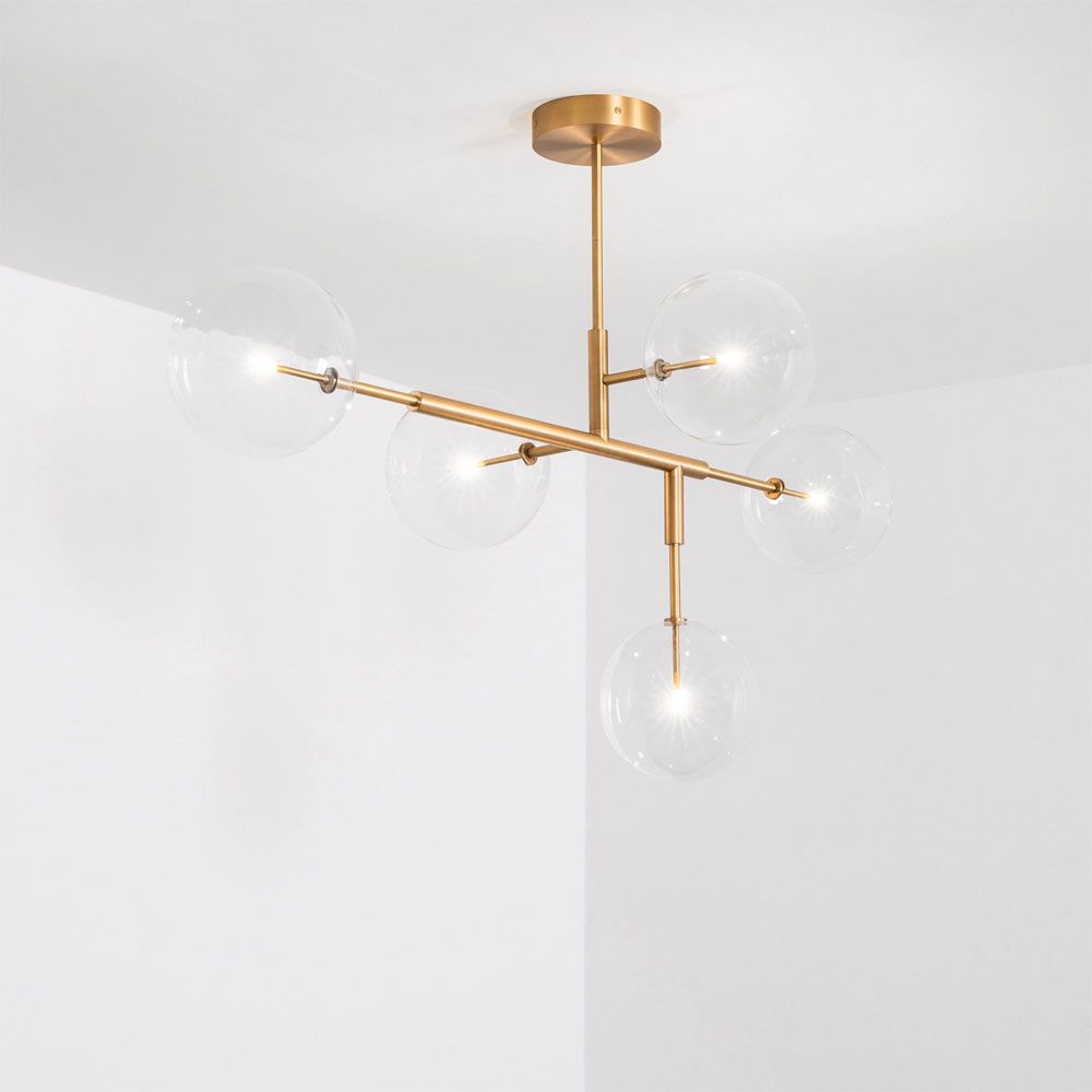 A luxurious lacquered burnished brass LED pendant with transparent glass lampshades