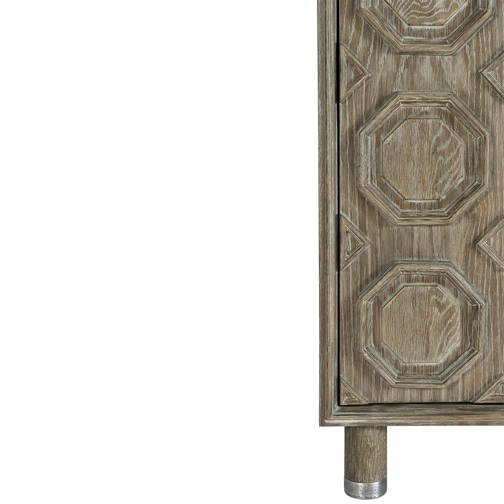 A textured wooden sideboard with four carved geometric patterned doors and finished with nickel plated aluminium legs