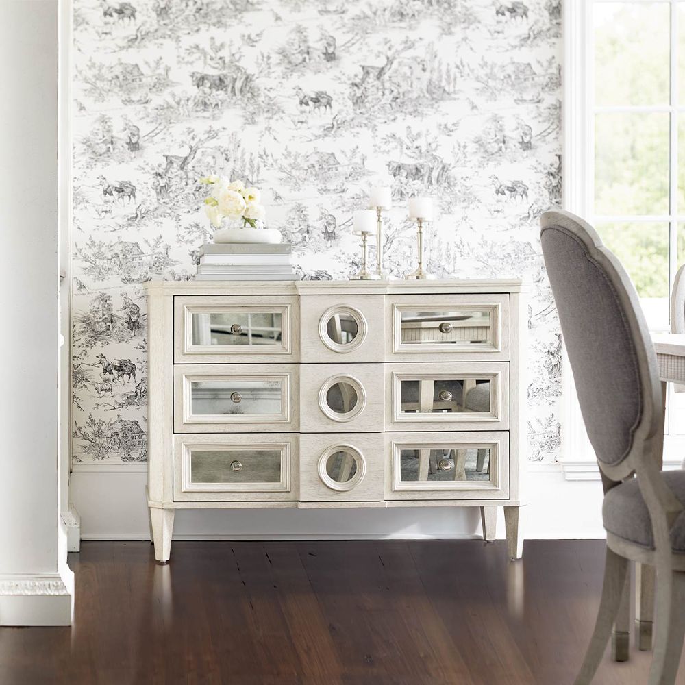 A luxury white oak veneer chest of drawers accentuated by antiqued mirrored glass panels with Silver Luster highlights and a Manor White finish