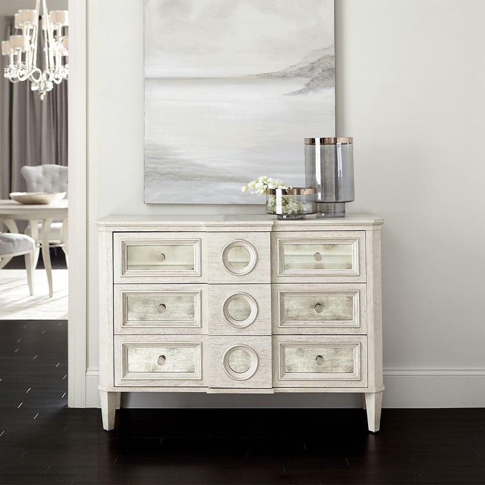 A luxury white oak veneer chest of drawers accentuated by antiqued mirrored glass panels with Silver Luster highlights and a Manor White finish