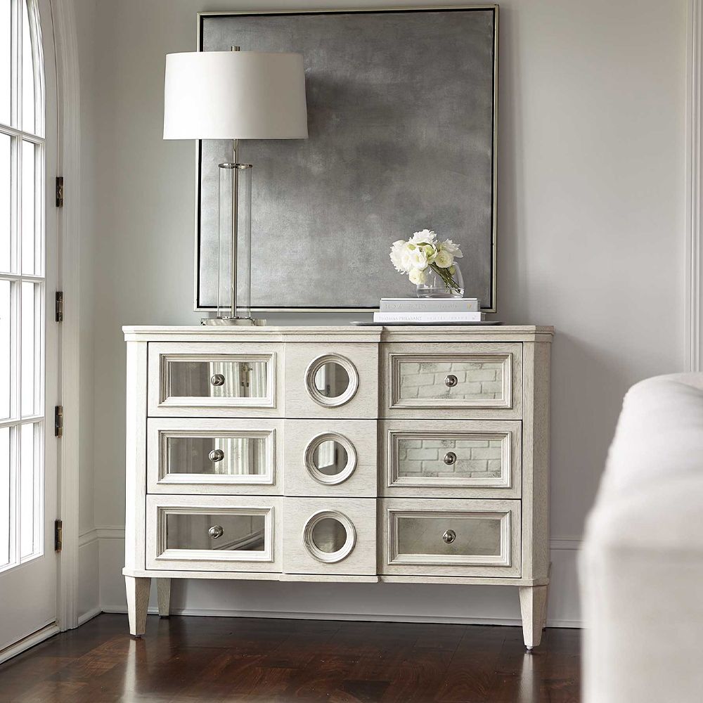 A luxury white oak veneer chest of drawers accentuated by antiqued mirrored glass panels with Silver Luster highlights and a Manor White finish