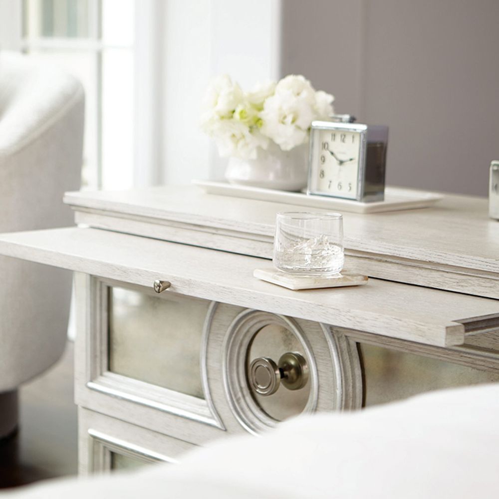 An elegant white oak veneer bedside table with two antiqued mirrored glass panel drawers, Silver Luster highlights and a Manor White finish