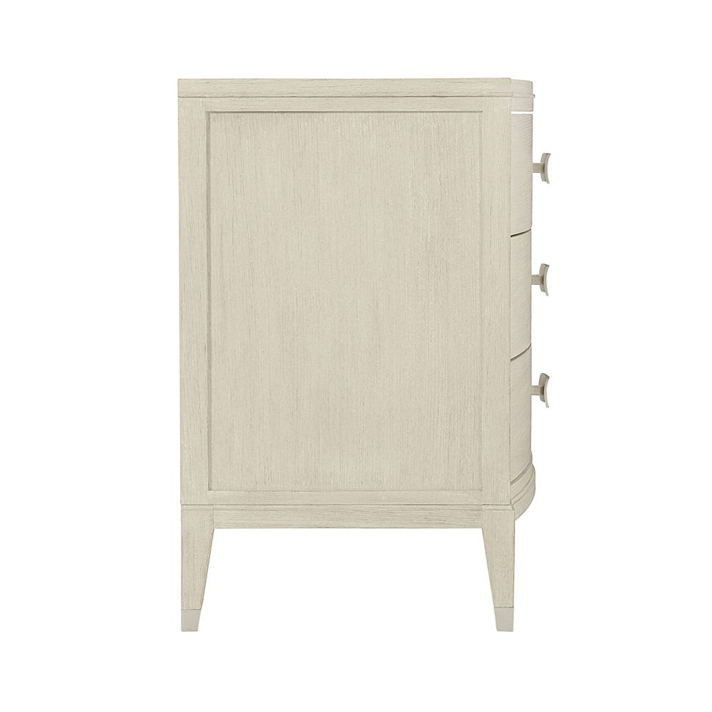 A chic minimal natural wood bedside table with tarnished nickel accents