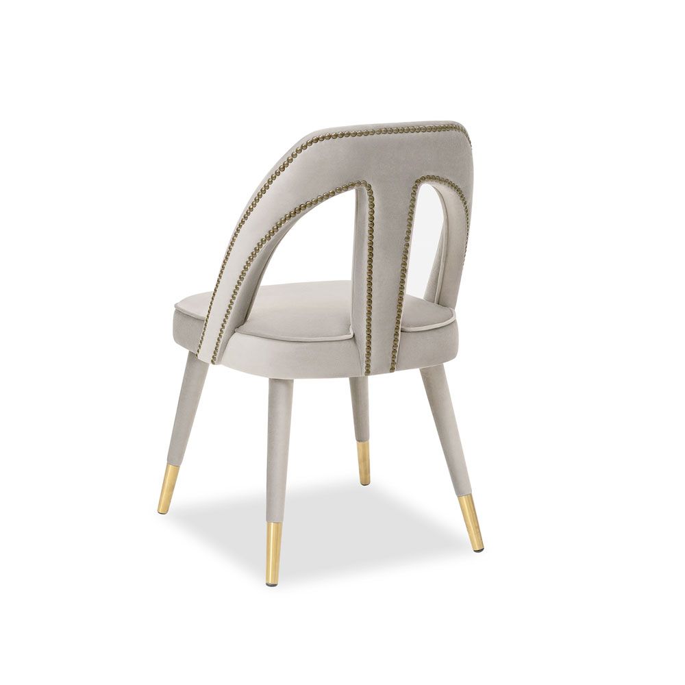 A luxury dining chair by Liang & Eimil with a gorgeous grey upholstery and brass detailing