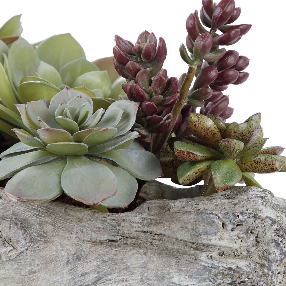 Artificial succulents on grey wooden plinth