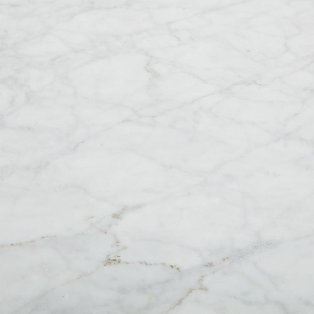 A luxurious dining table by Jonathan Adler with a white Carrara marble top and T-shaped legs crafted from solid oak 