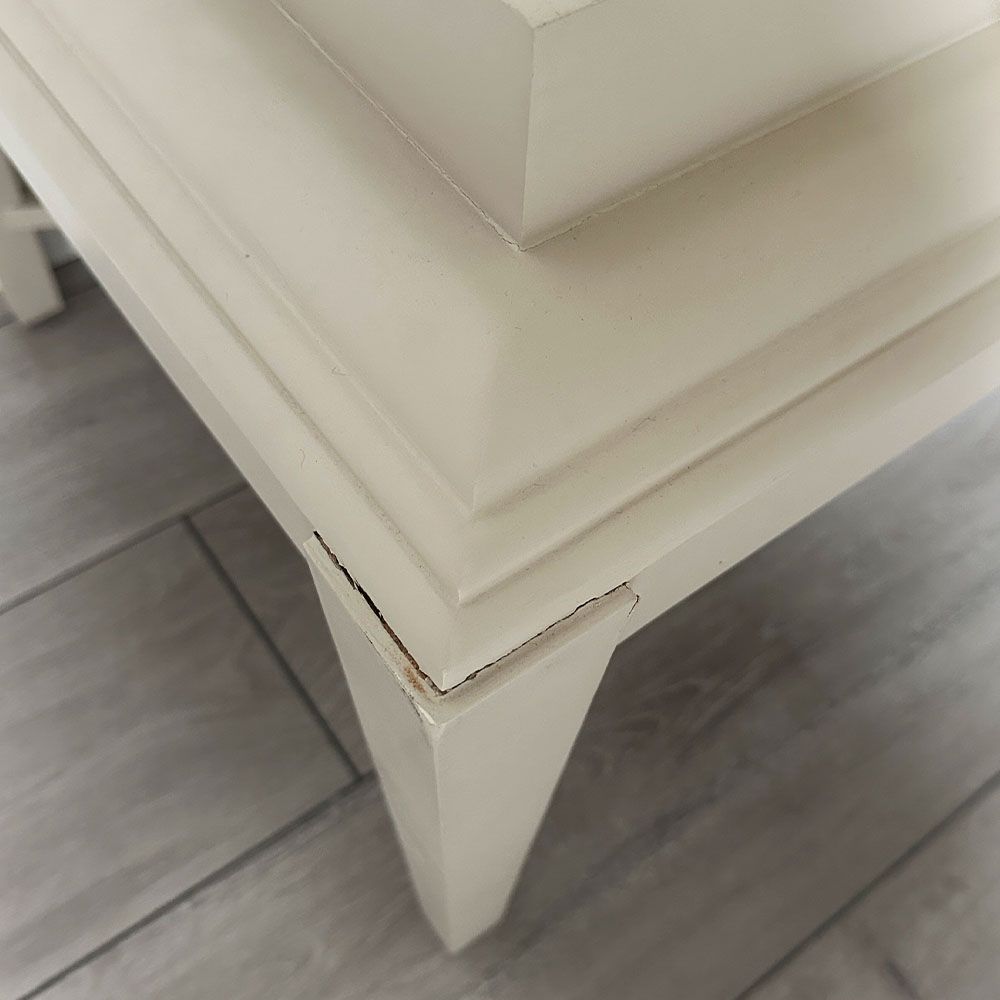 Pale grey table with four solid legs and a bordered top surface