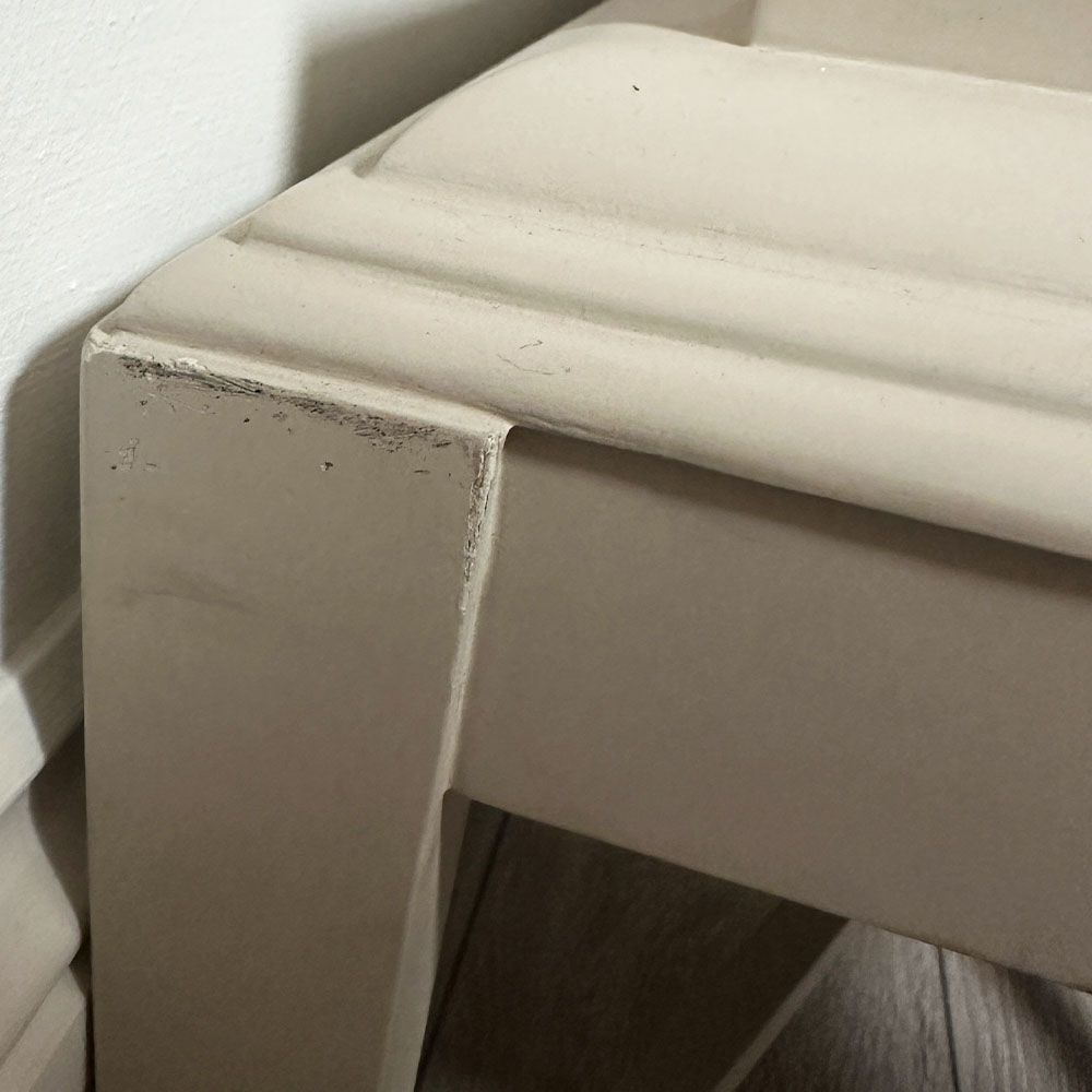 Pale grey table with four solid legs and a bordered top surface