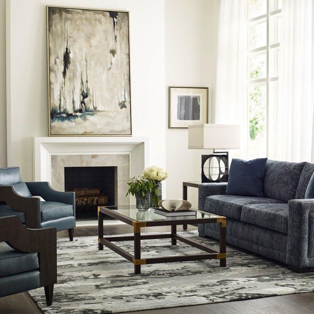 A stylish coffee table by Theodore Alexander with brushed brass corners
