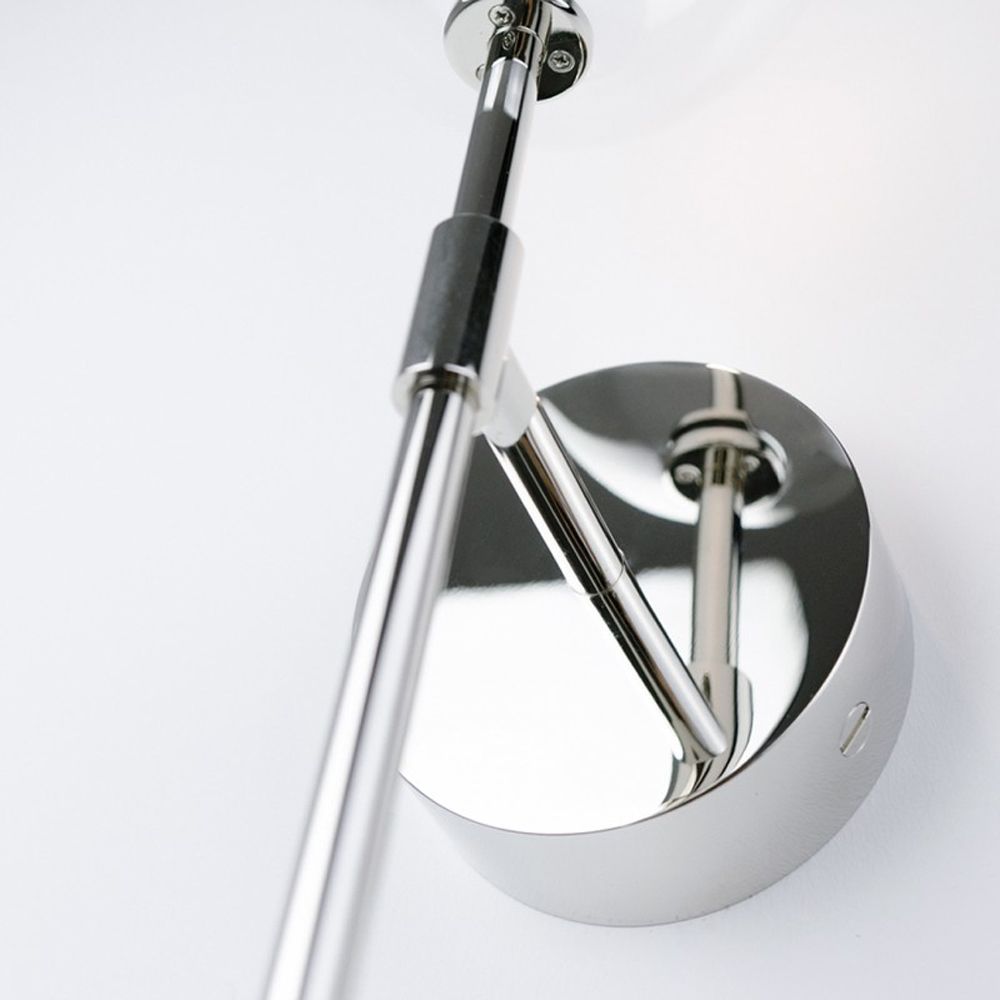 Contemporary industrial wall lamp in polished nickel finish with a large clear glass sphere lampshade