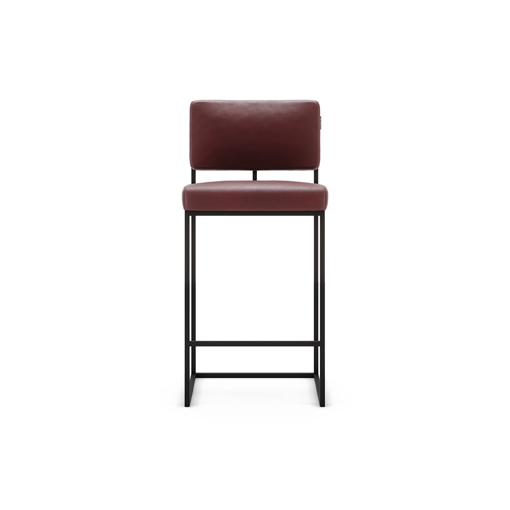 A luxurious modern counter stool with a minimal black metal frame and natural leather upholstery