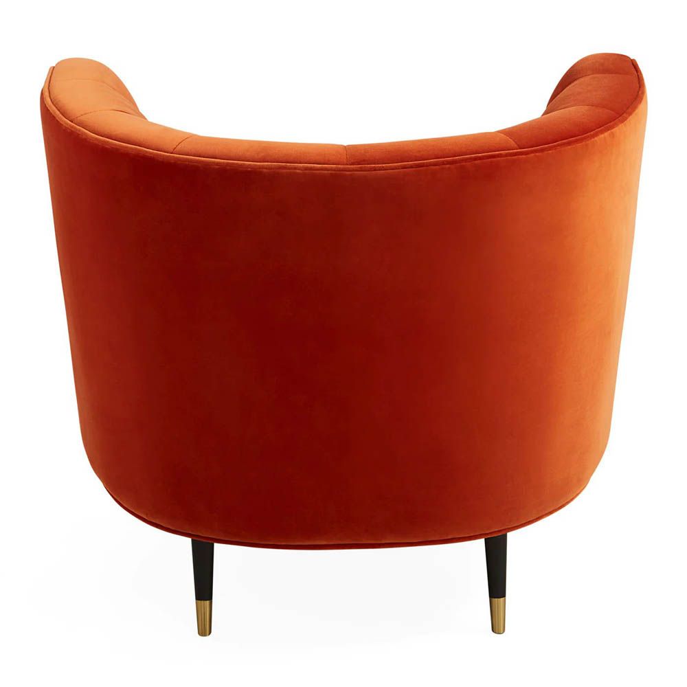 A luxury armchair by Jonathan Adler with a gorgeous red upholstery and beautiful brass capped feet