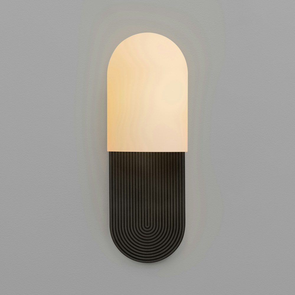 Wall sconce with a linear design engraved fitting and misted glass shade
