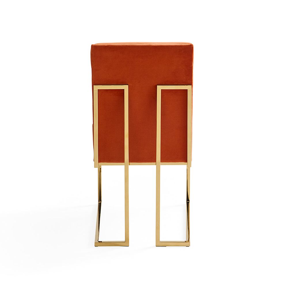 A luxury dining chair by Jonathan Adler with a polished brass base and 70s style red ribbed design