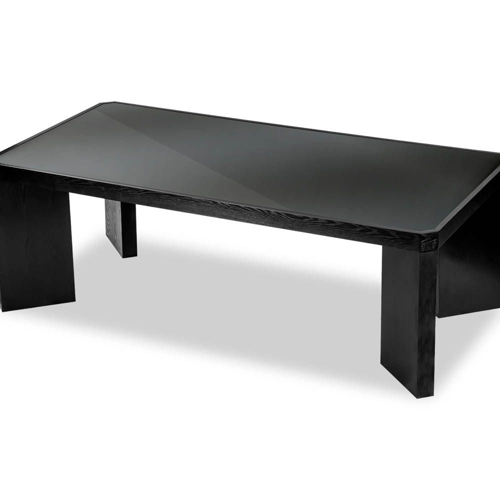 Wide legged dining table in black wood finish with glass top