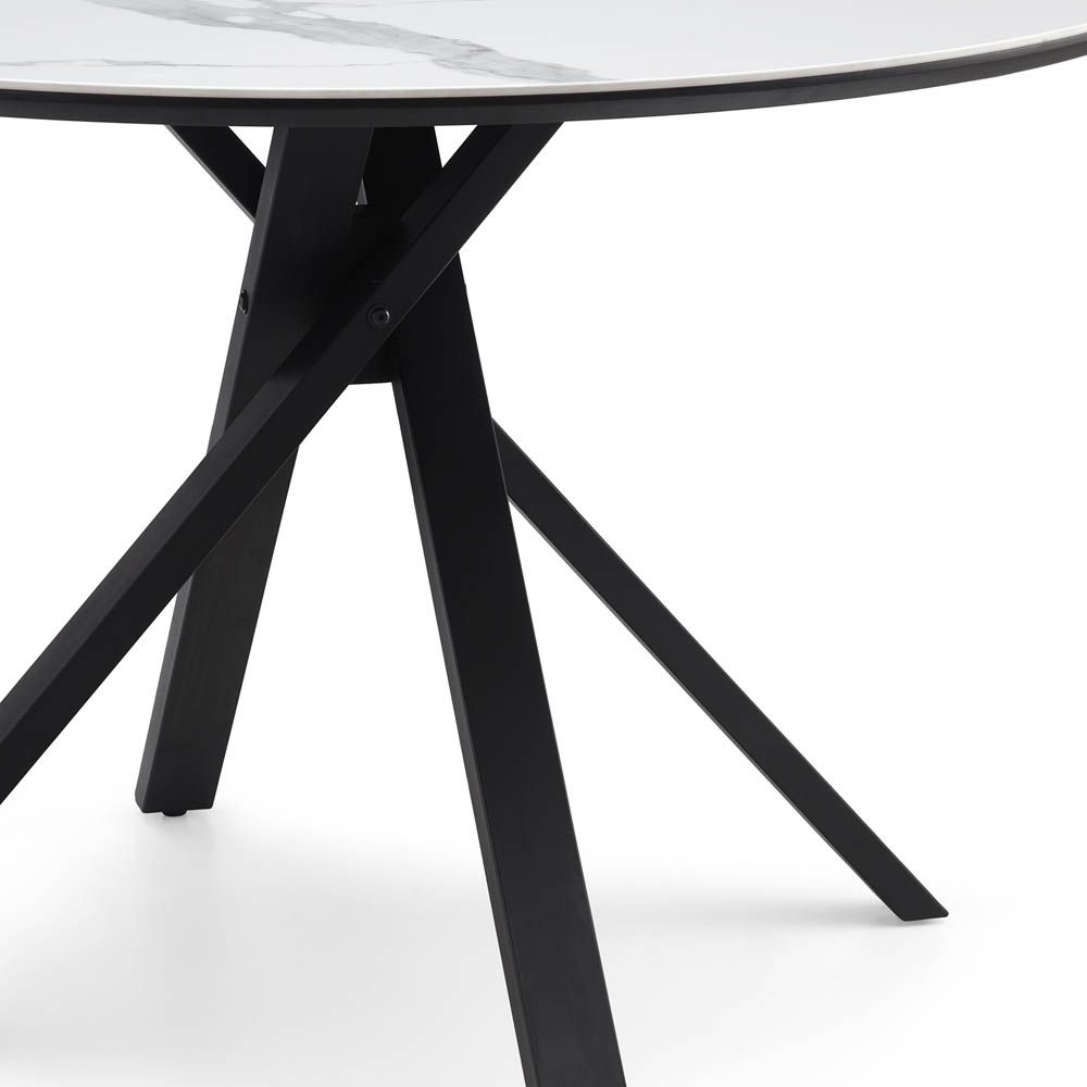 Round, white marble top dining table with dynamic crossed over legs