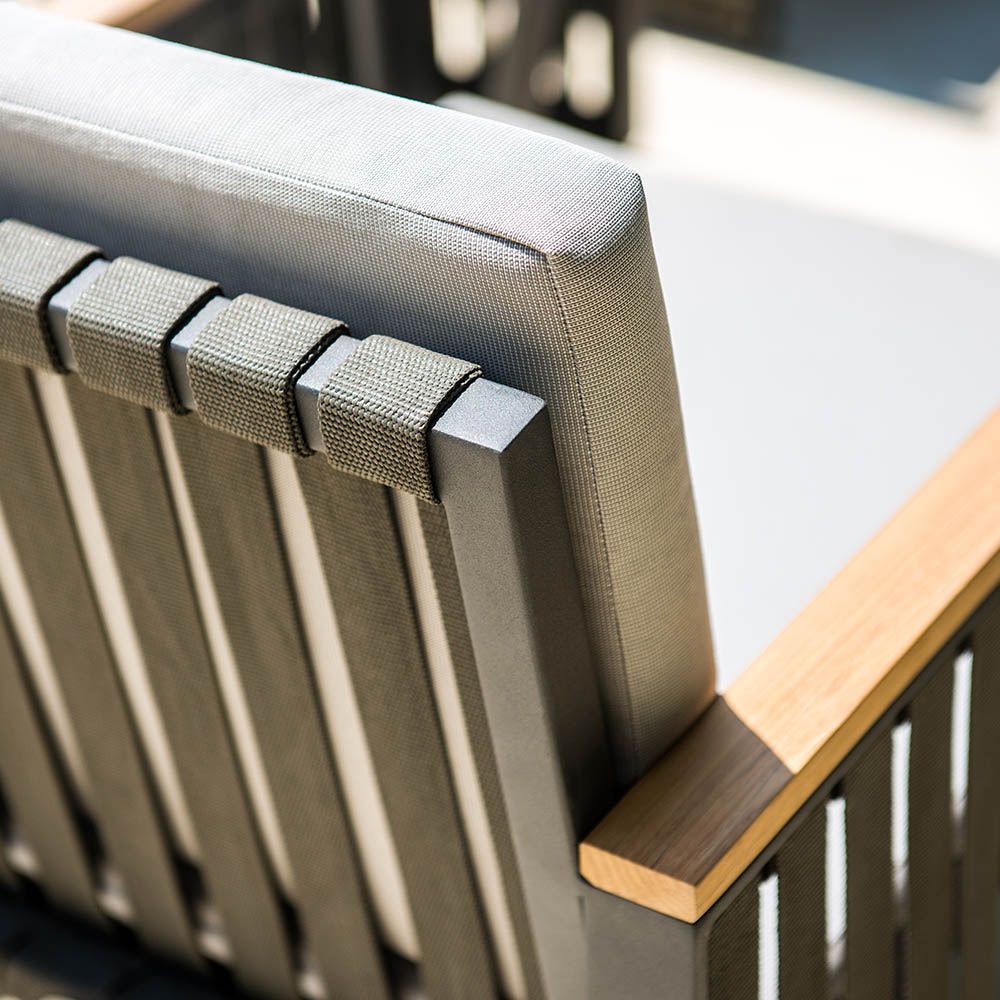 A stylish outdoor dining chair with grey strapping and bespoke sunbrella cushions 