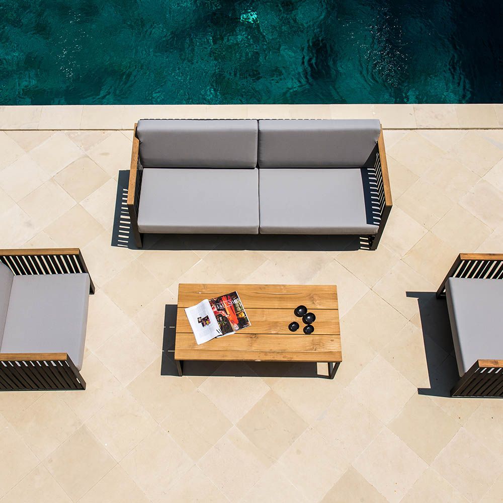 A luxury outdoor sofa from Willow's Outdoor collection with a bespoke sunbrella cushion upholstery and grey strapping