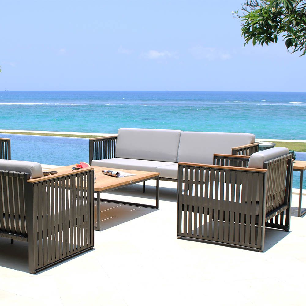 A sophisticated armchair from Willow's Outdoor collection with a bespoke sunbrella cushion upholstery and grey strapping