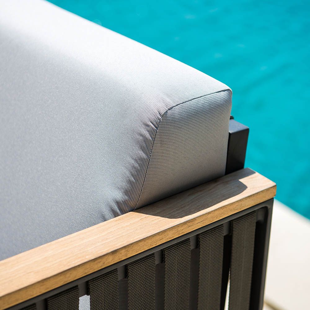 A sophisticated armchair from Willow's Outdoor collection with a bespoke sunbrella cushion upholstery and grey strapping