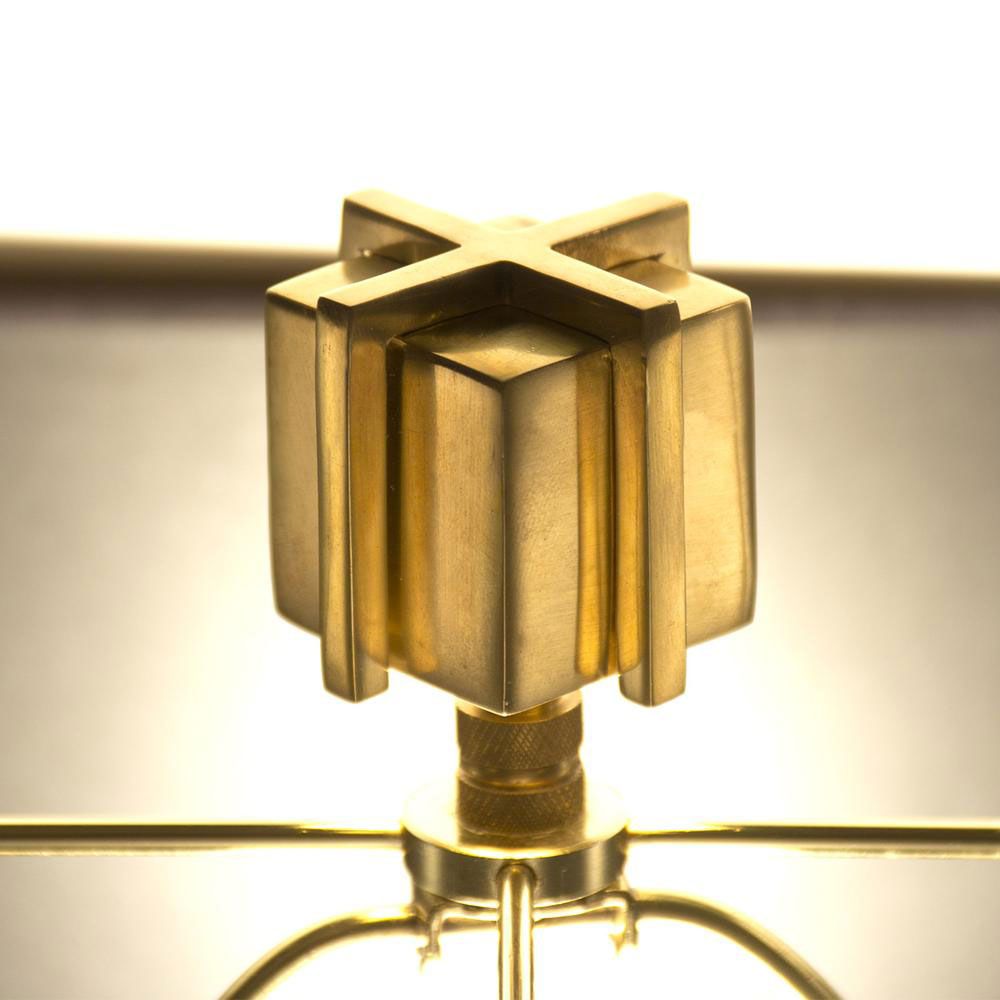 A luxurious sculptural side lamp with layers of solid brass and black lampshade