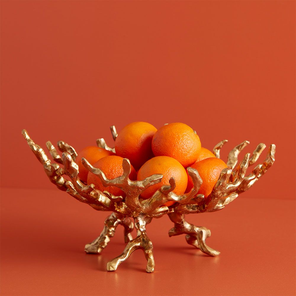 A luxury brass bowl by Jonathan Adler with a chic coral design 