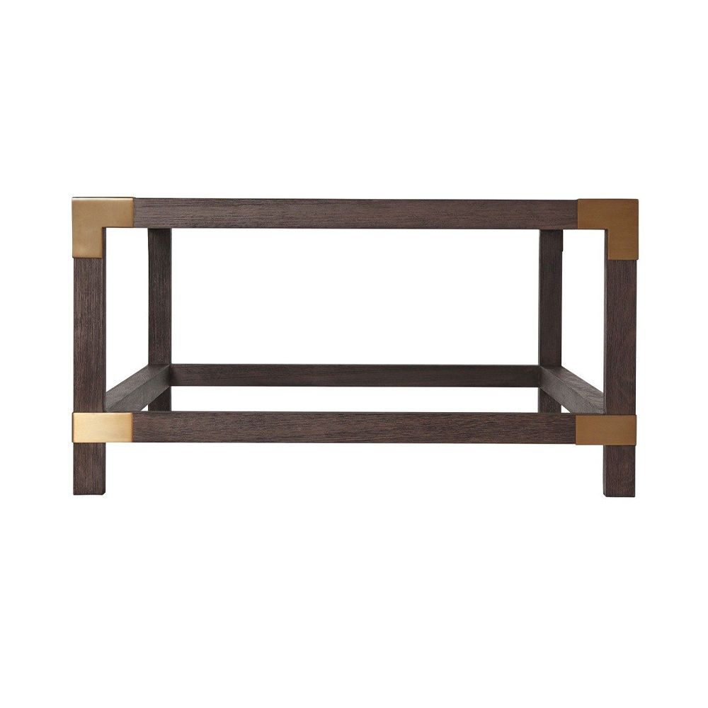 A stylish coffee table by Theodore Alexander with brushed brass corners