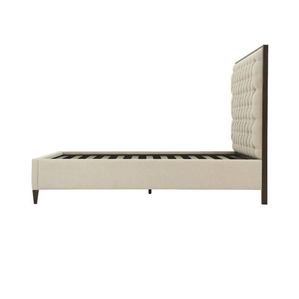 A stunning bed from Theodore Alexander with a neutral, deep-buttoned headboard and a dark solid beech frame