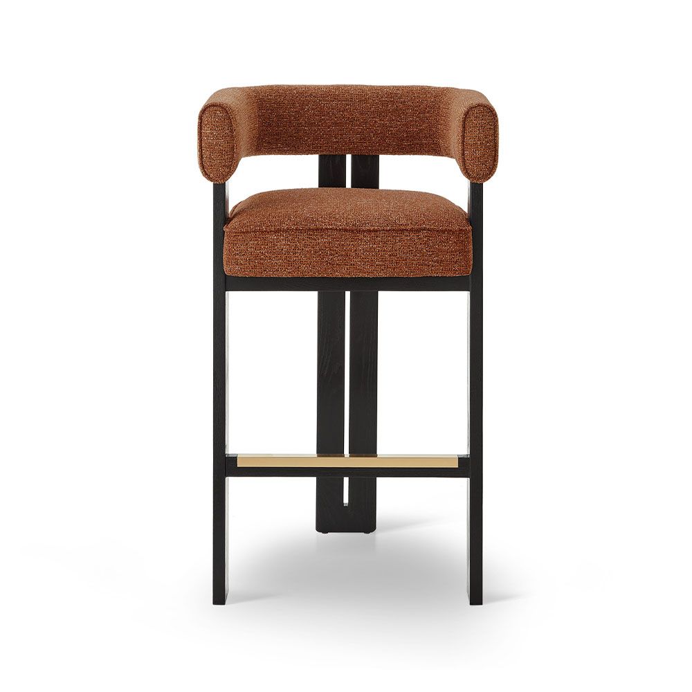 A luxury bar stool with a striking vibrant upholstery and brass detailing