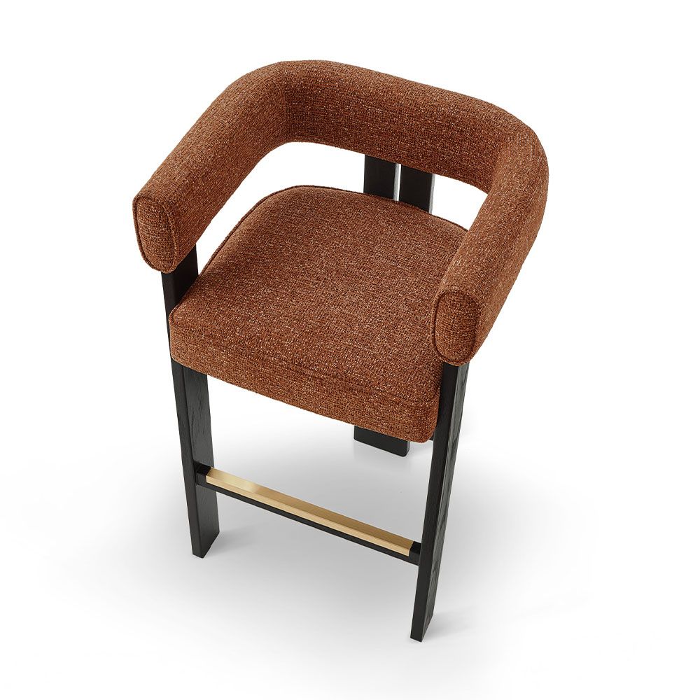 A luxury bar stool with a striking vibrant upholstery and brass detailing