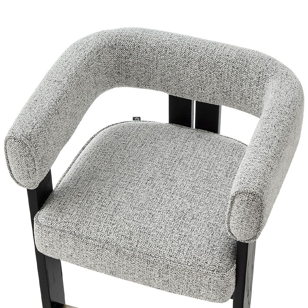 A luxury counter stool with a gorgeous grey upholstery and brass detailing
