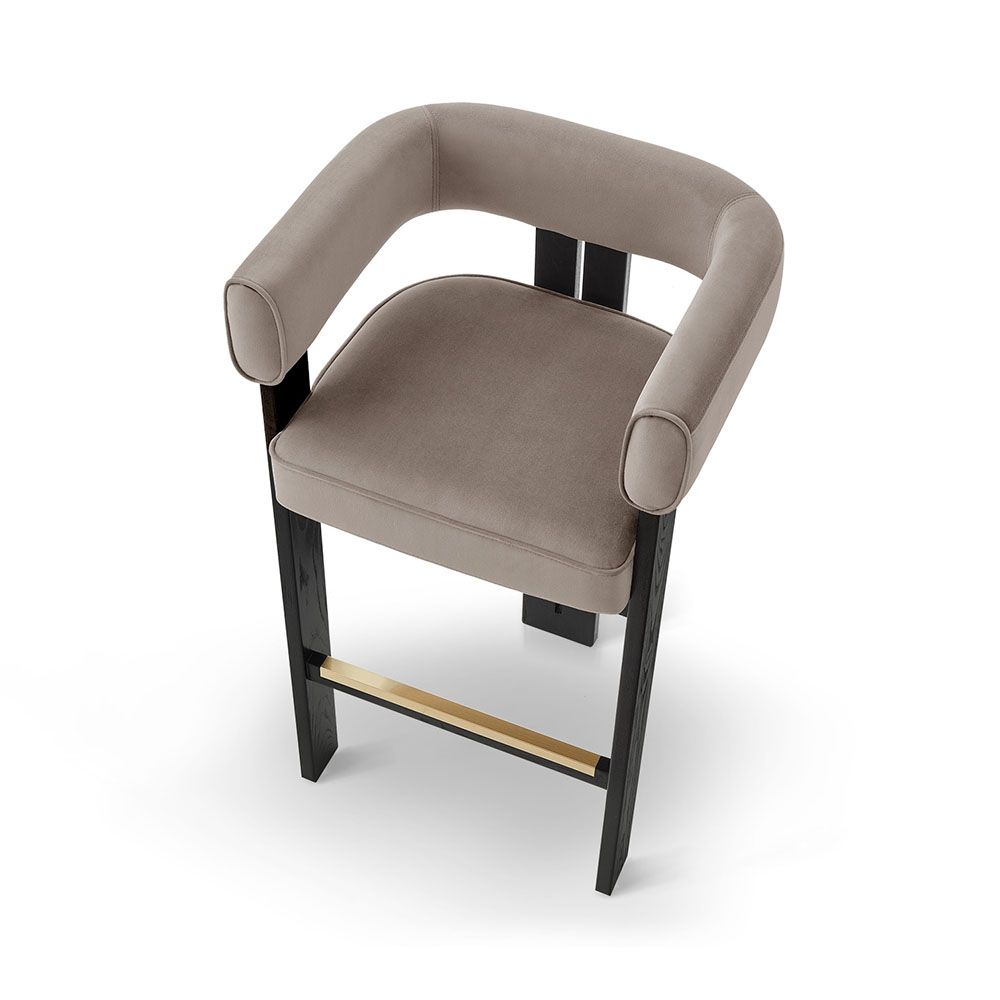 A luxury bar stool with a luxury grey velvet upholstery and brass detailing