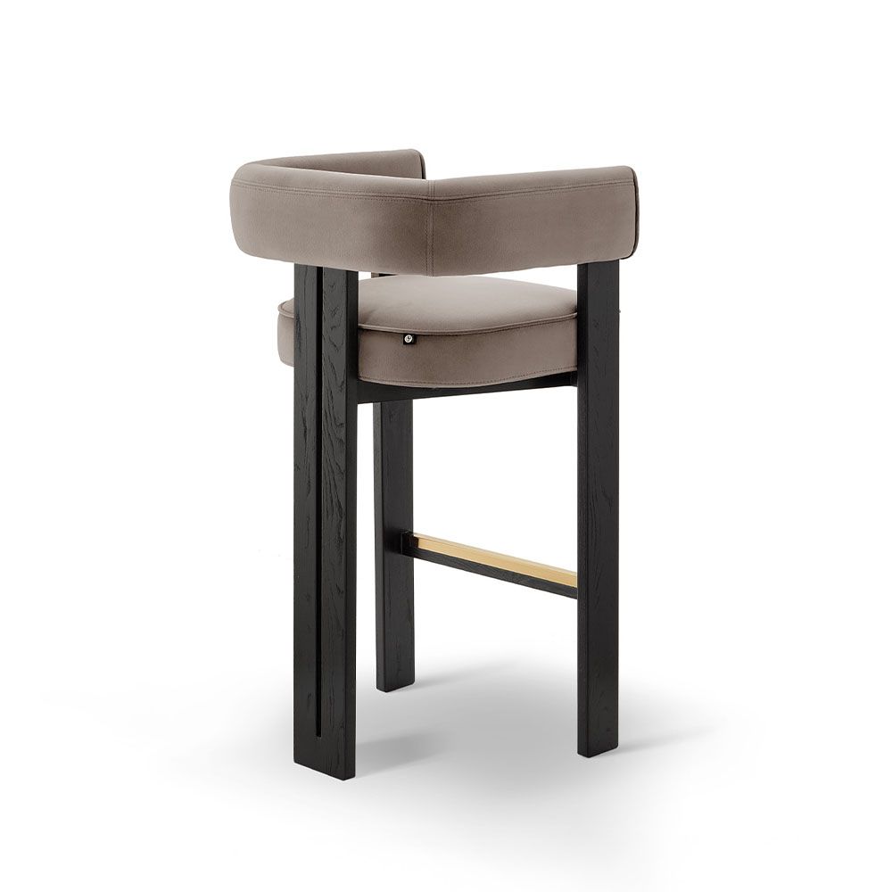 A luxury bar stool with a luxury grey velvet upholstery and brass detailing