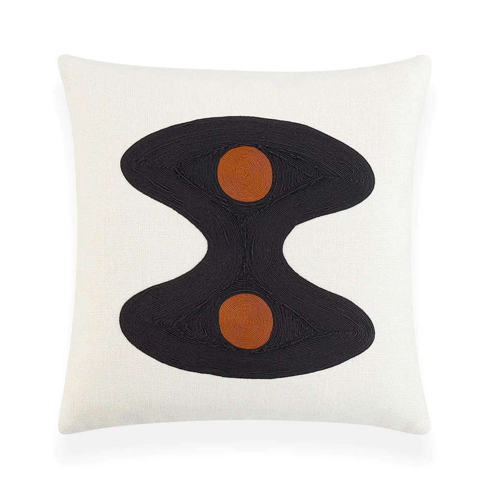 White cushion with black wavy shape and two orange circles