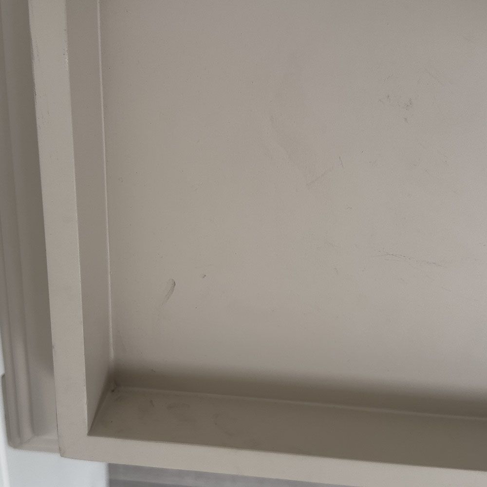 Pale grey table with four solid legs and a bordered top surface