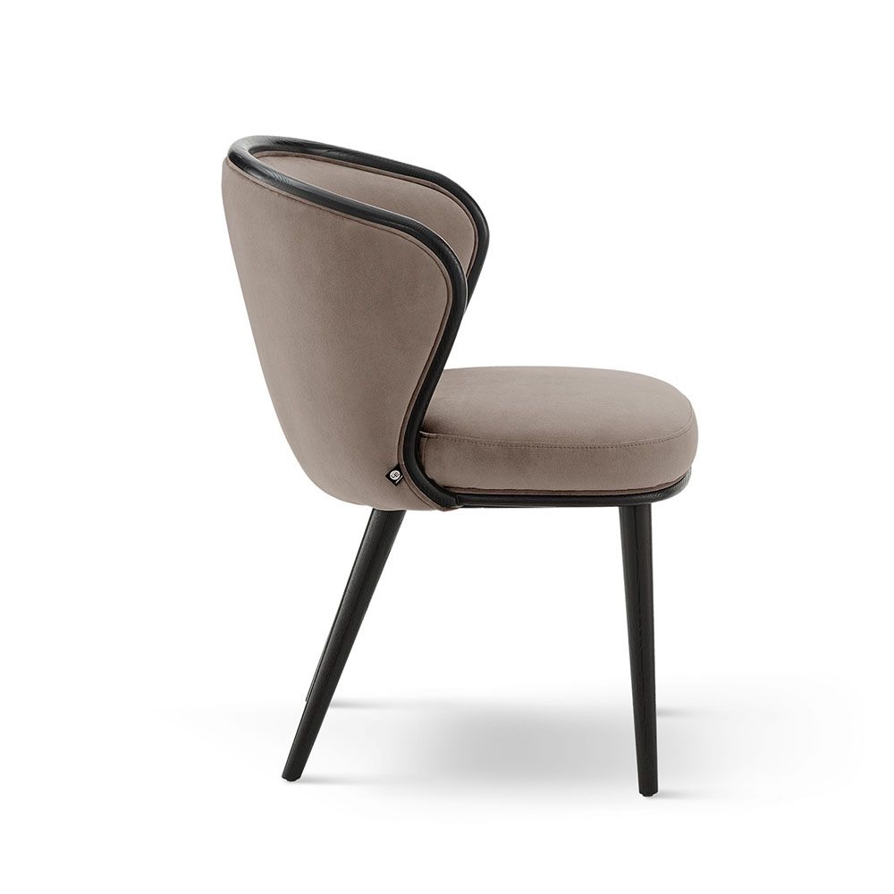 A luxury recycled velvet upholstered dining chair with a curved backrest