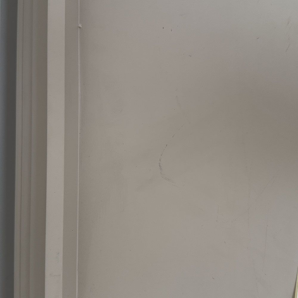 Pale grey table with four solid legs and a bordered top surface