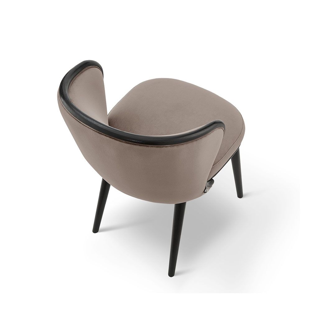 A luxury recycled velvet upholstered dining chair with a curved backrest