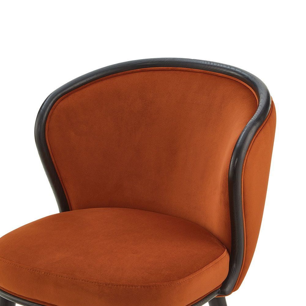 A statement recycled velvet upholstered dining chair with a curved backrest