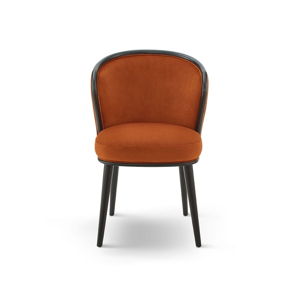 A statement recycled velvet upholstered dining chair with a curved backrest